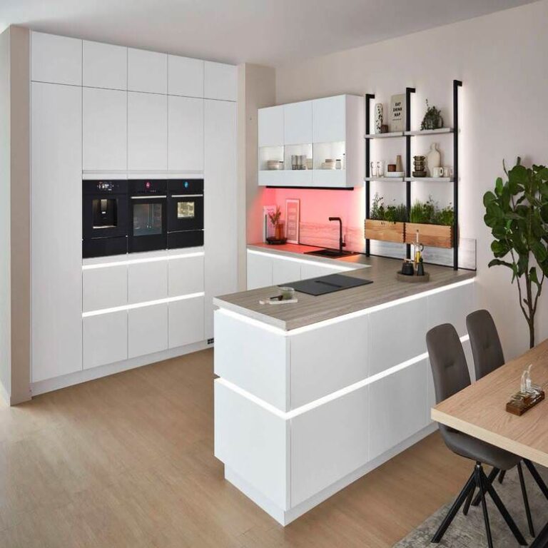 Moderne grifflose Küche in Weiß mit beleuchteter Kochinsel und Kräuterregal – Küchenstudio Magdeburg